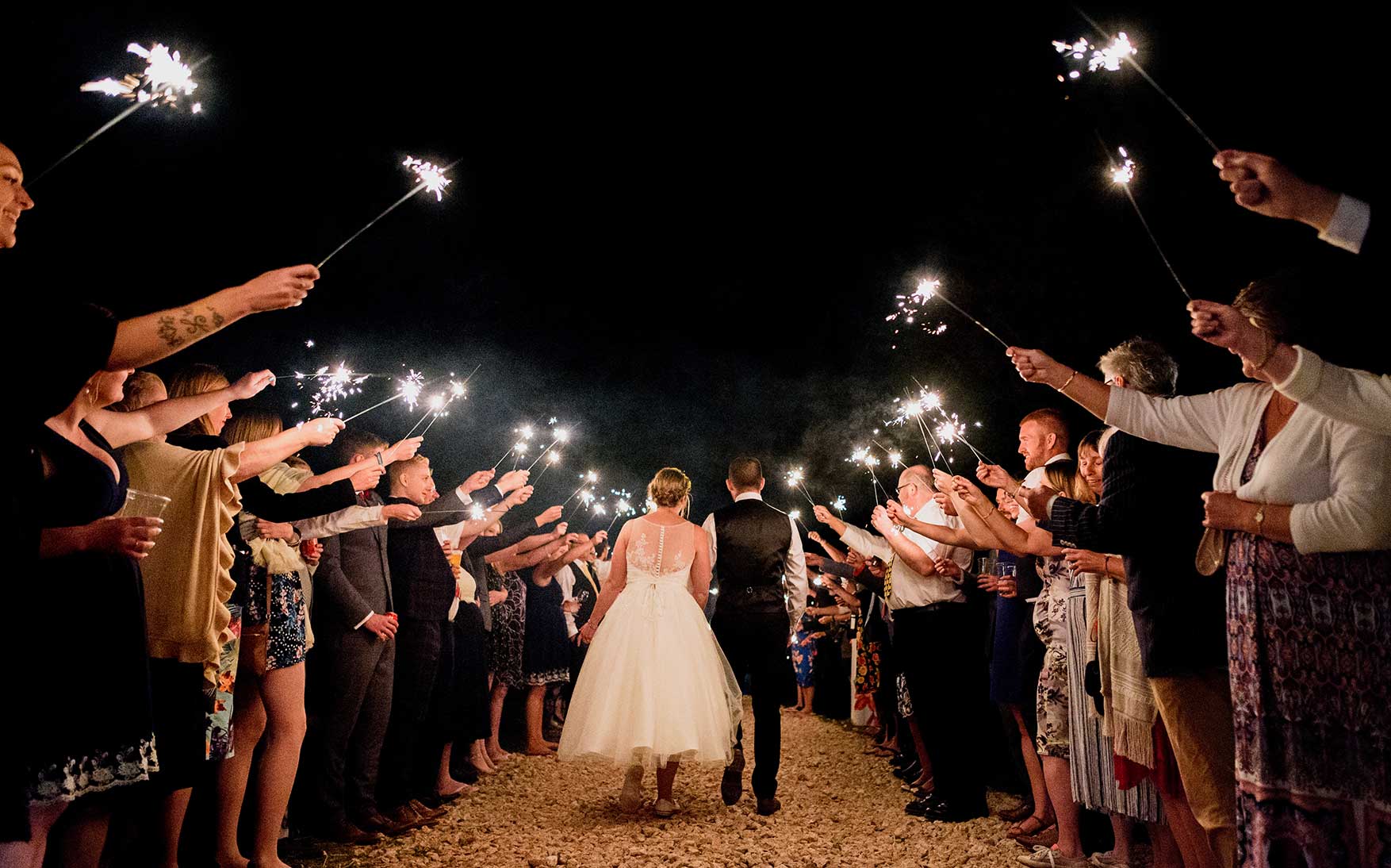 Guests hole up sparklers to salute the happy couple